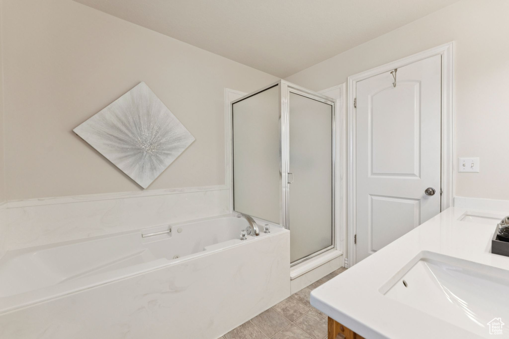 Full bath featuring a shower stall, a garden tub, and double vanity