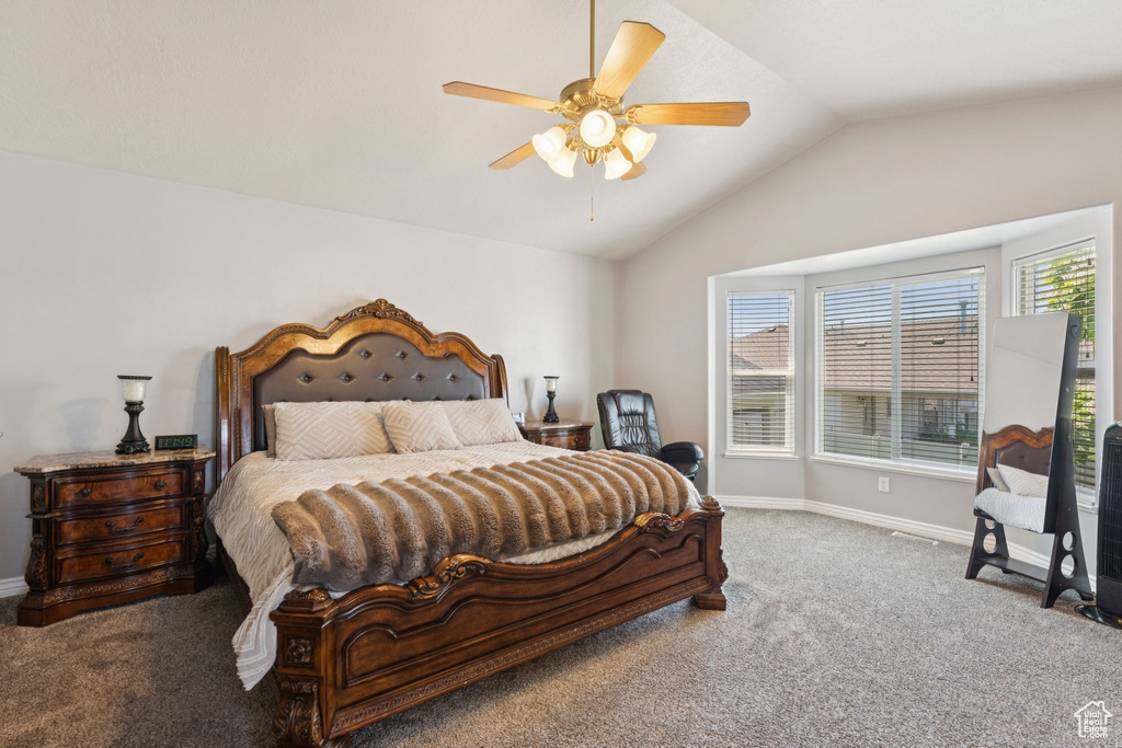 Bedroom with carpet flooring, vaulted ceiling, baseboards, and a ceiling fan