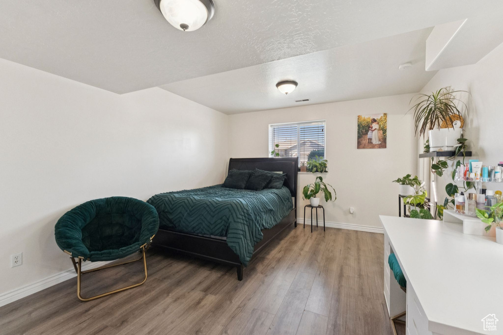Bedroom with wood finished floors and baseboards
