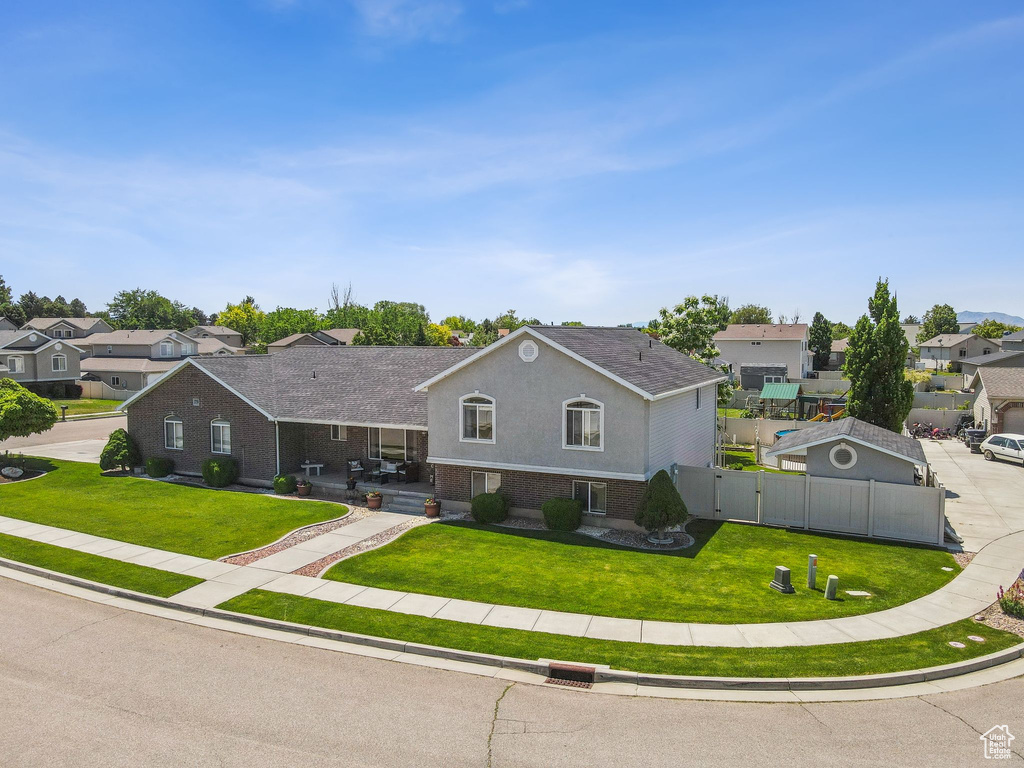 View of front of home with a residential view, brick siding, and a gate