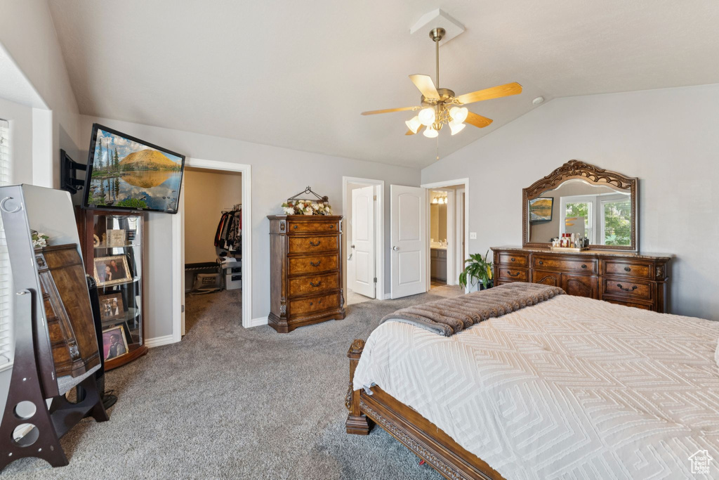 Bedroom featuring lofted ceiling, a walk in closet, carpet floors, a closet, and ensuite bathroom
