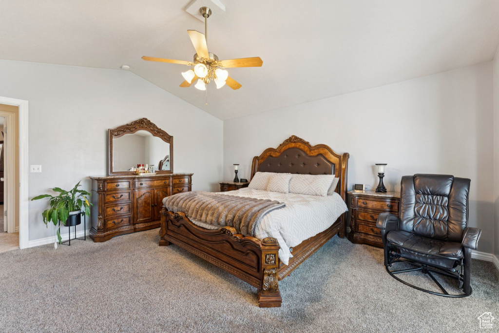 Carpeted bedroom with lofted ceiling, baseboards, and a ceiling fan