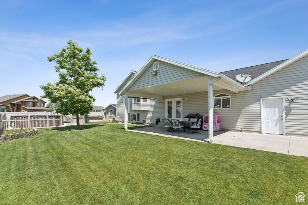 Back of property with a patio area and roof with shingles