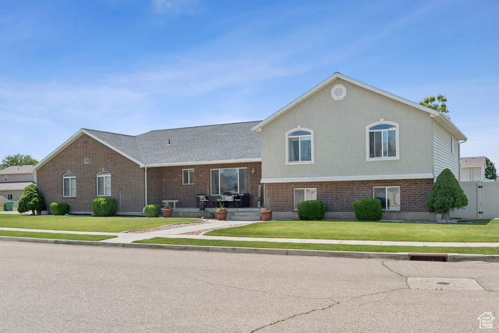 View of front facade featuring brick siding and a front lawn