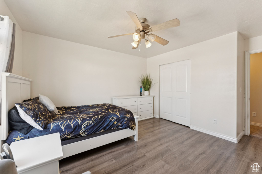 Bedroom with wood finished floors, baseboards, and ceiling fan