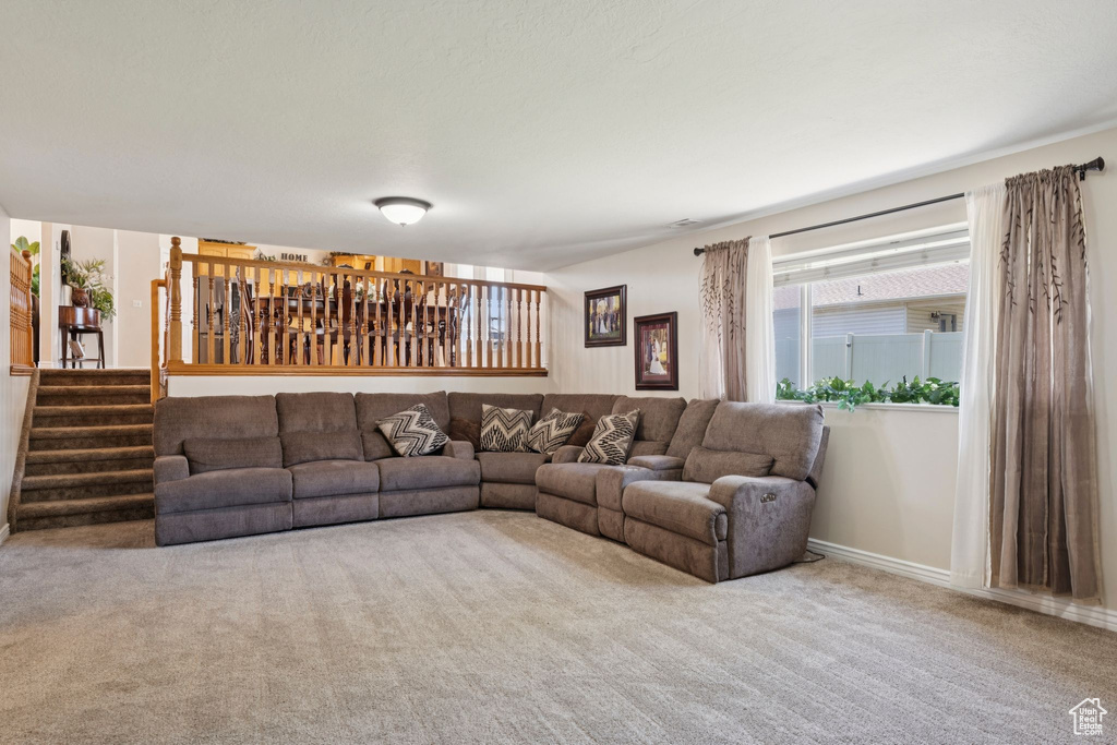 Living area with carpet floors, stairs, and baseboards