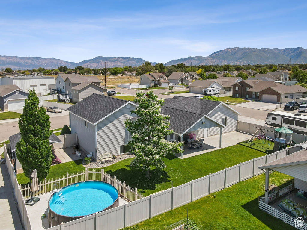 Aerial perspective of suburban area with a mountainous background and a pool