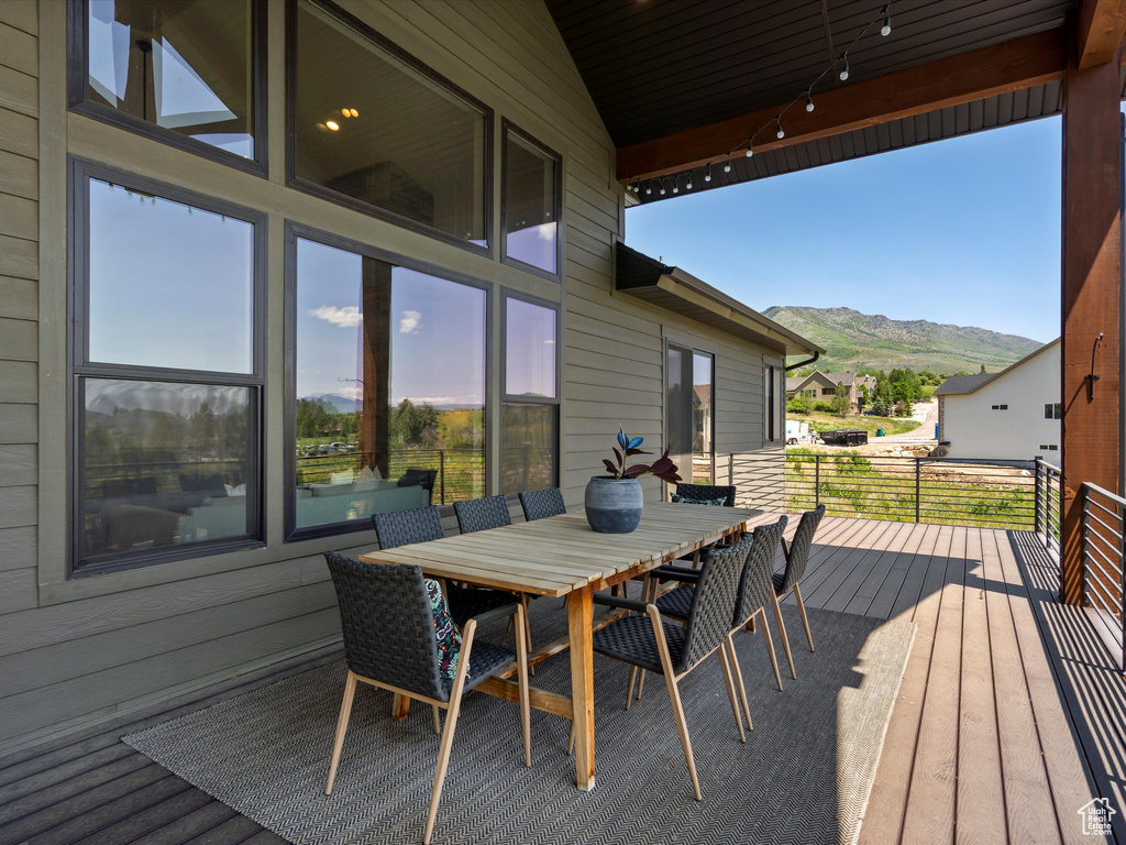 Wooden deck featuring a mountain view and outdoor dining space