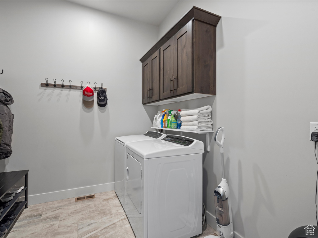Laundry room with independent washer and dryer, cabinet space, and baseboards