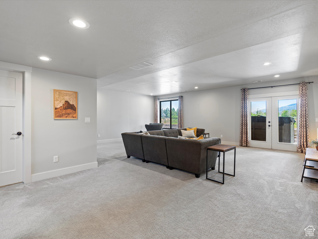 Living area featuring light carpet, recessed lighting, baseboards, and french doors