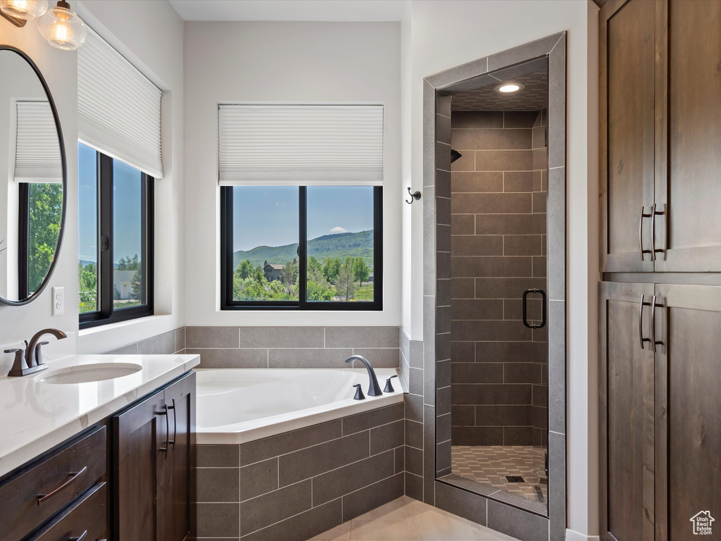 Full bathroom with vanity, a shower stall, and a garden tub