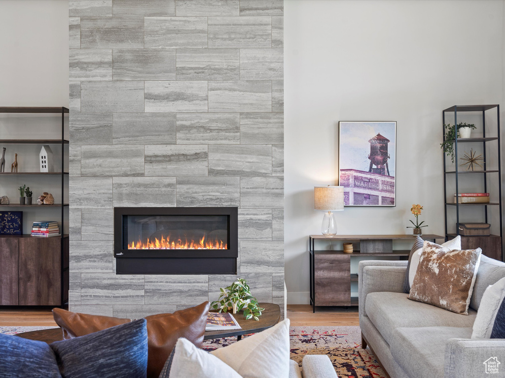 Living room featuring a tiled fireplace and wood finished floors