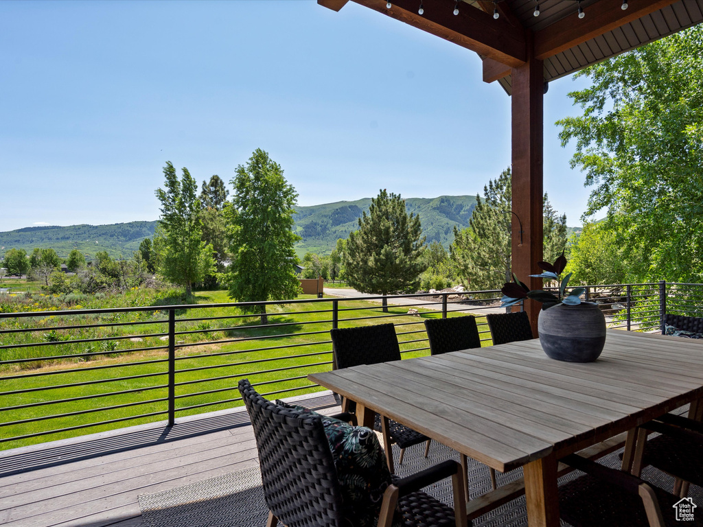 Deck with a mountain view and outdoor dining space