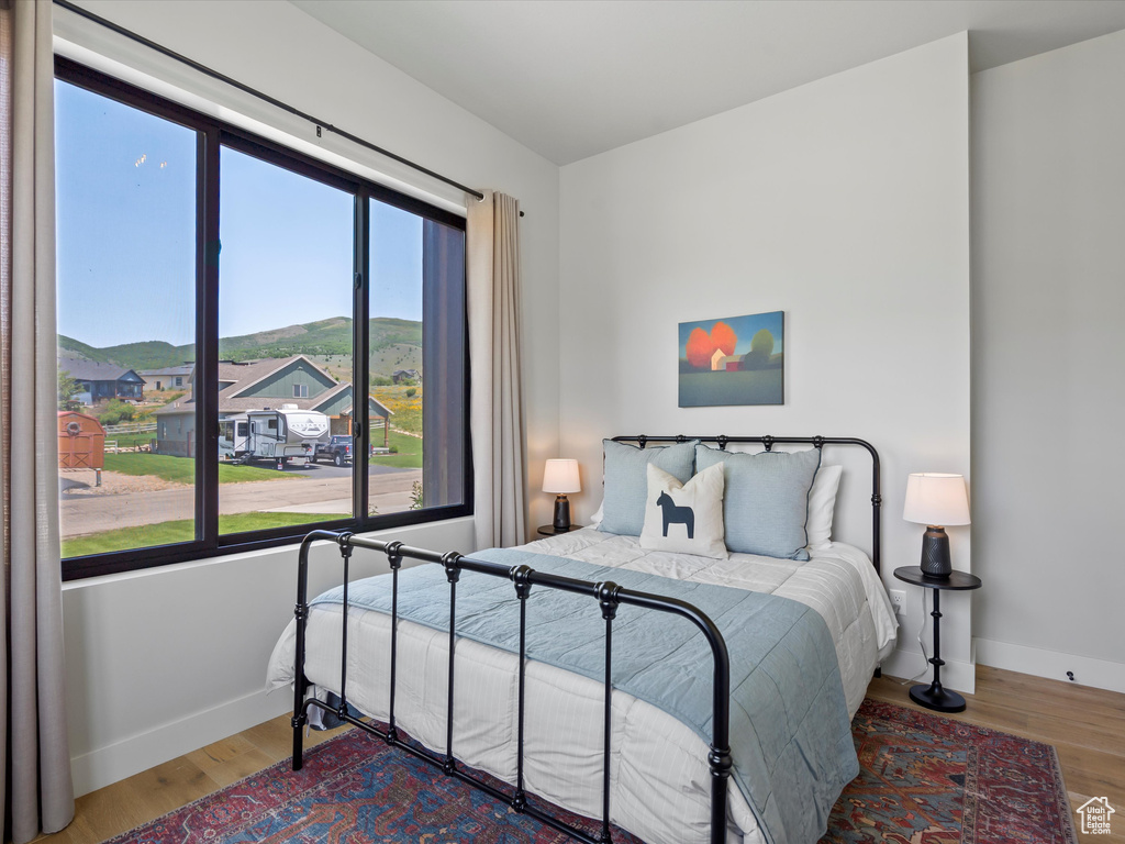 Bedroom featuring baseboards, wood finished floors, and a mountain view