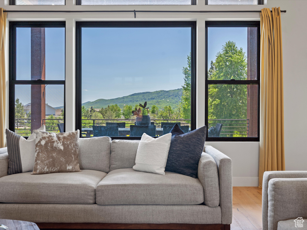 Living area featuring wood finished floors, a mountain view, and baseboards