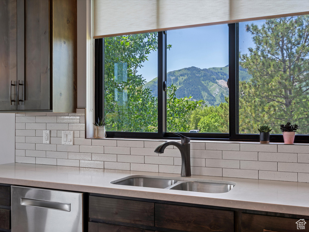 Kitchen featuring a sink, dishwasher, light countertops, tasteful backsplash, and dark brown cabinetry