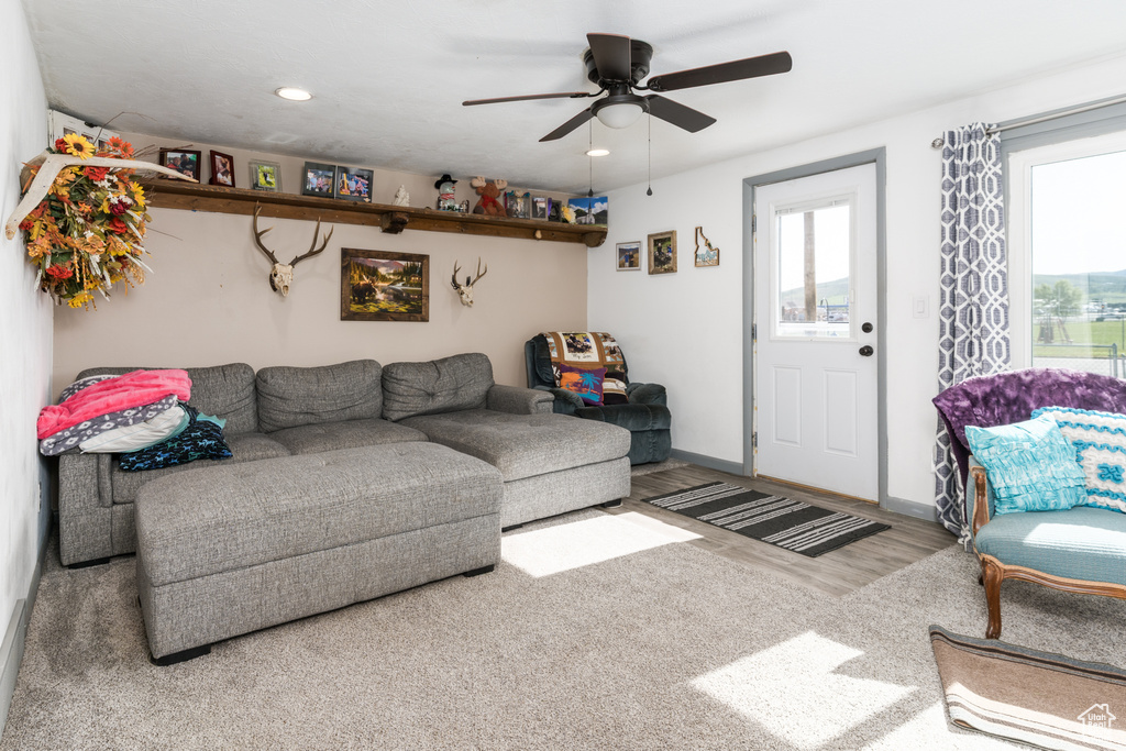 Living area featuring healthy amount of natural light, ceiling fan, wood finished floors, recessed lighting, and baseboards
