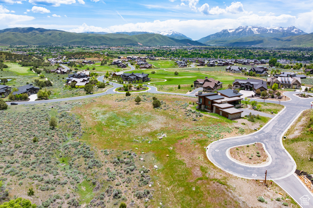 Aerial view of residential area with a mountainous background and a golf club