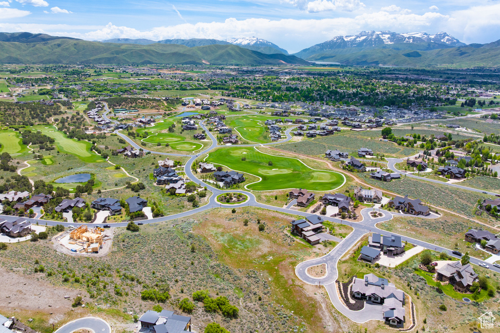 Aerial view of property and surrounding area featuring a local golf course, nearby suburban area, and a water and mountain view