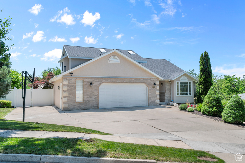 View of front of home featuring an attached garage, concrete driveway, and brick siding