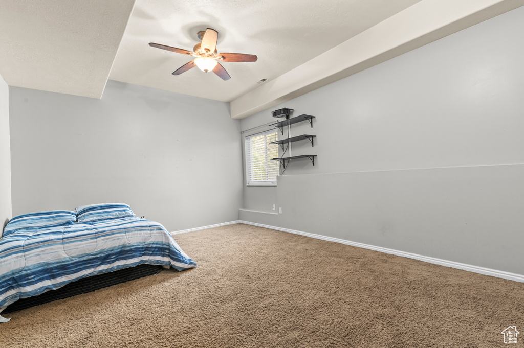 Unfurnished bedroom featuring carpet floors, baseboards, and ceiling fan
