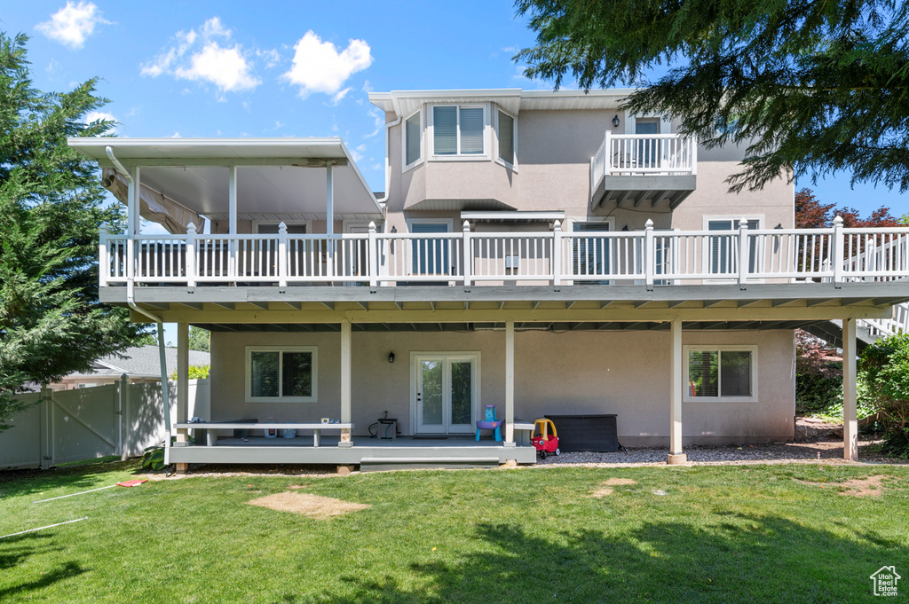 Rear view of house with a deck, french doors, and stucco siding