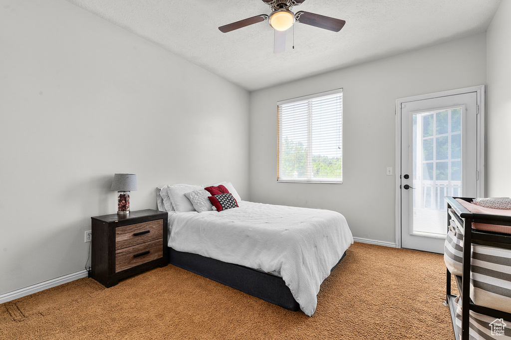 Bedroom featuring access to outside, light colored carpet, baseboards, and ceiling fan