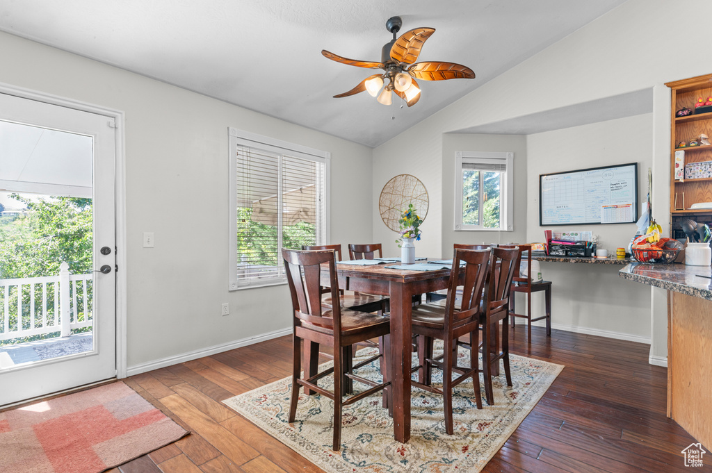 Dining area featuring hardwood / wood-style flooring, lofted ceiling, ceiling fan, and baseboards