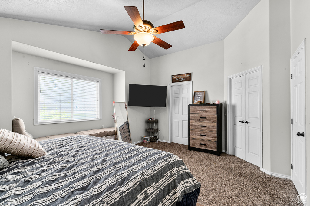 Bedroom with carpet floors, high vaulted ceiling, a ceiling fan, and baseboards