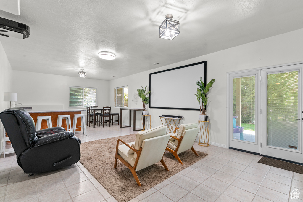 Living area featuring light tile patterned floors and a textured ceiling