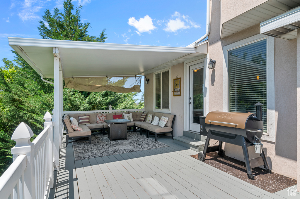 Wooden deck with an outdoor hangout area and area for grilling