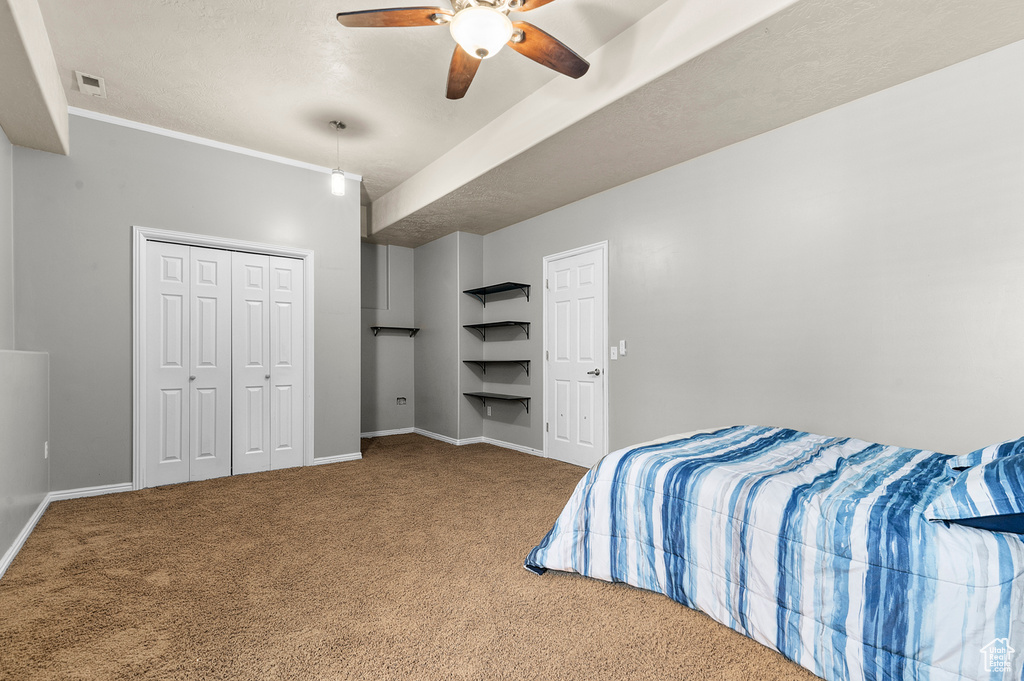 Bedroom featuring carpet, baseboards, ceiling fan, and a closet