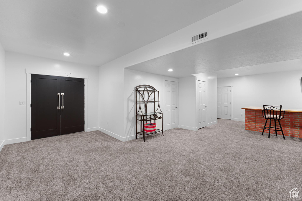 Carpeted foyer entrance with recessed lighting and baseboards