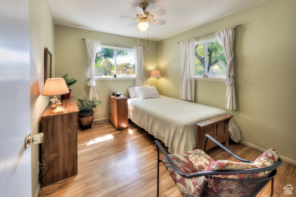 Bedroom featuring hardwood / wood-style flooring, baseboards, and a ceiling fan