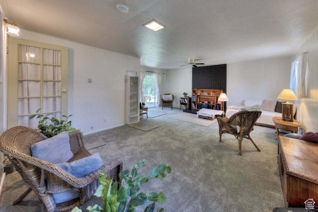 Carpeted living room with ceiling fan and a heating unit