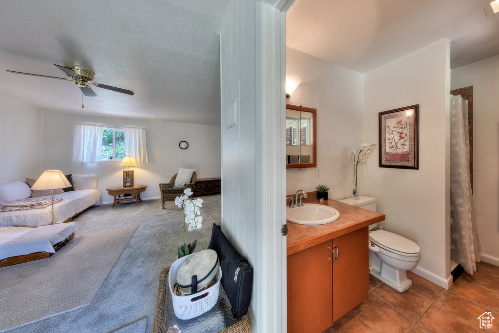 Bathroom with vanity, toilet, a ceiling fan, and a shower with curtain