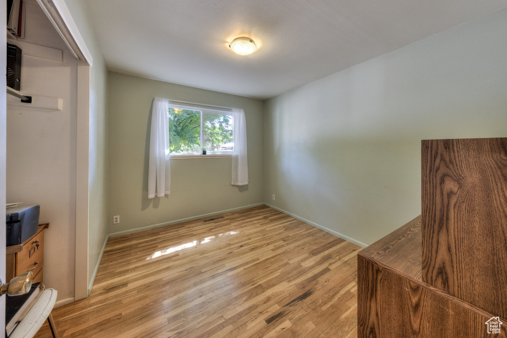Unfurnished bedroom featuring light wood-type flooring and baseboards