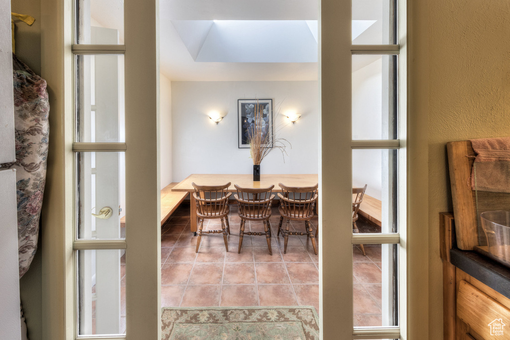 Dining space featuring tile patterned floors and a textured wall