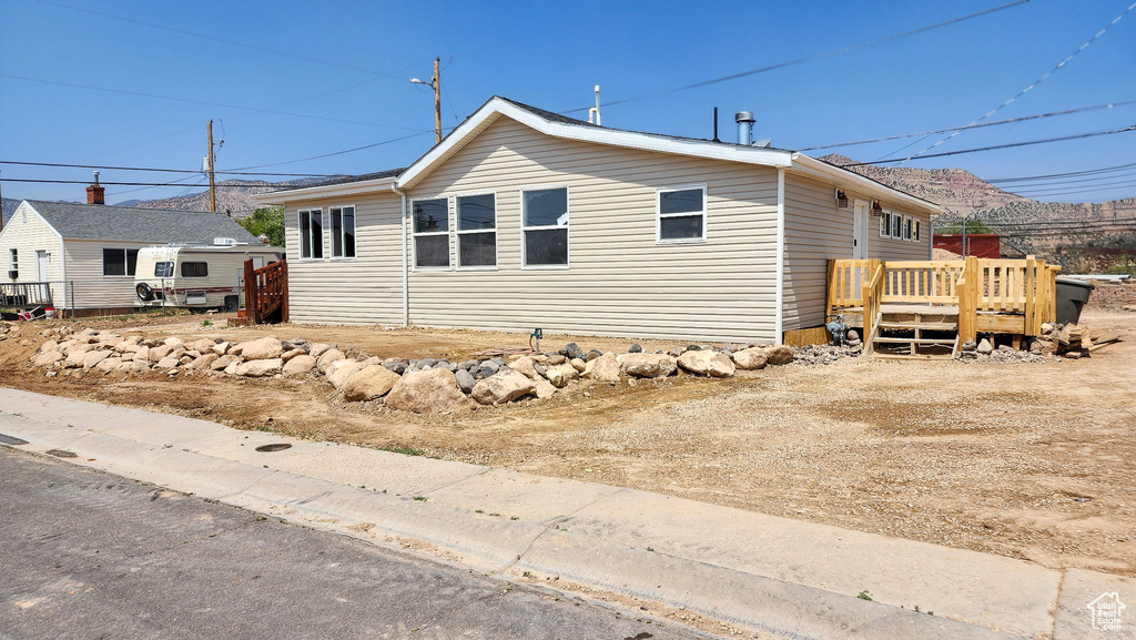 View of property exterior featuring a wooden deck