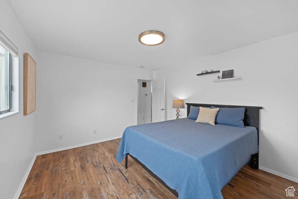 Bedroom with wood finished floors and baseboards