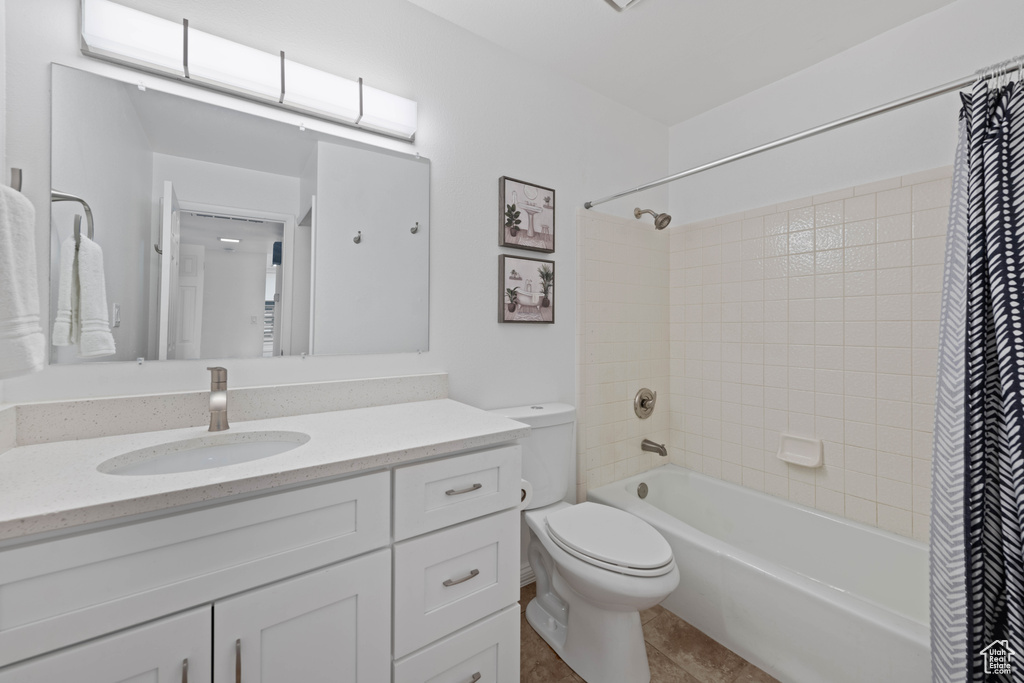 Full bath with vanity, shower / bathtub combination with curtain, toilet, and tile patterned floors
