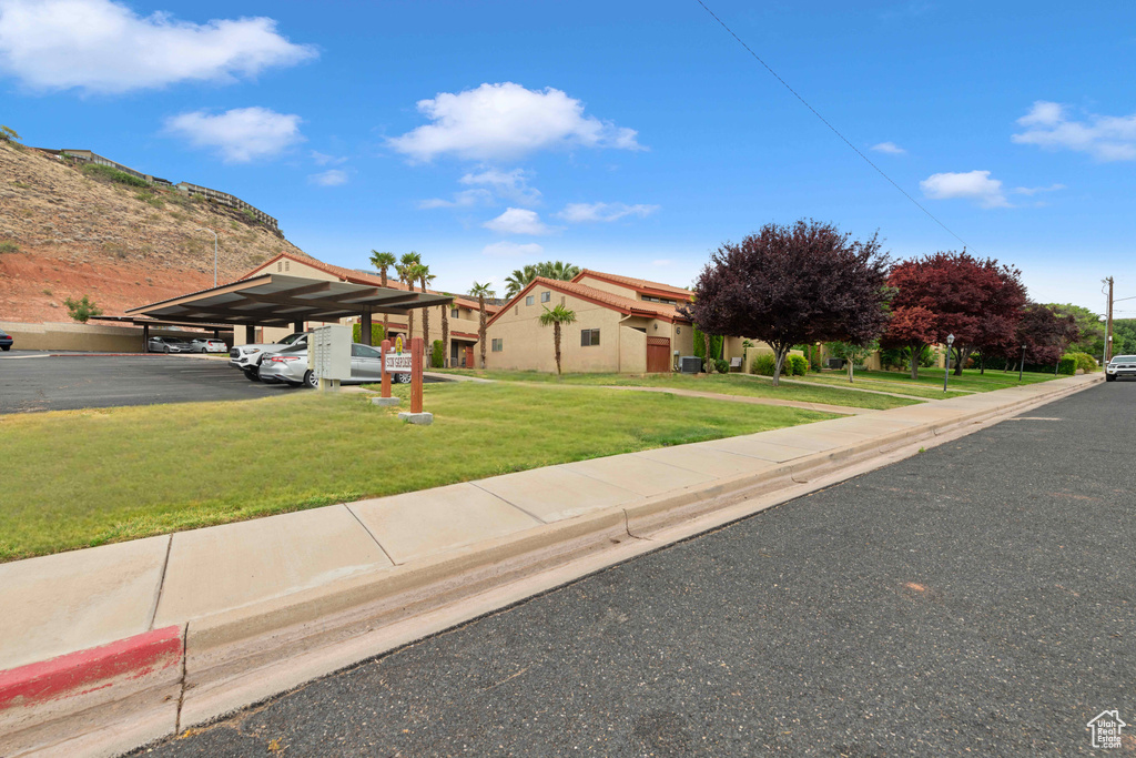 View of front facade with a front lawn and covered parking