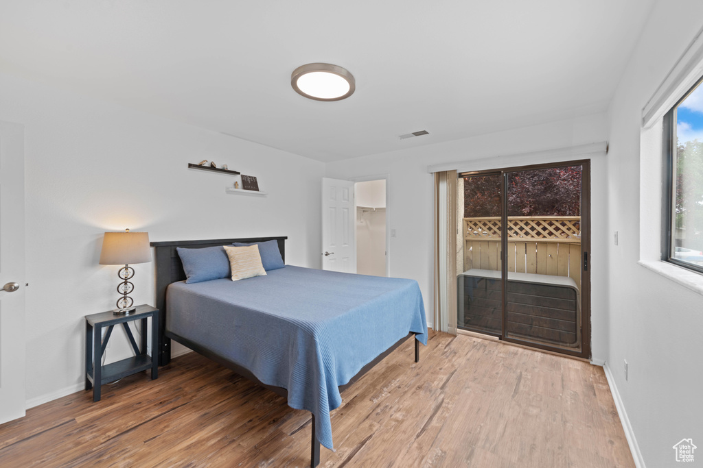 Bedroom featuring access to outside, wood finished floors, and baseboards