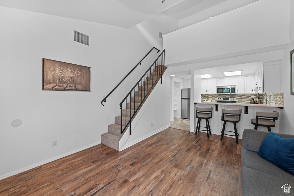 Living area featuring baseboards, stairs, and dark wood finished floors