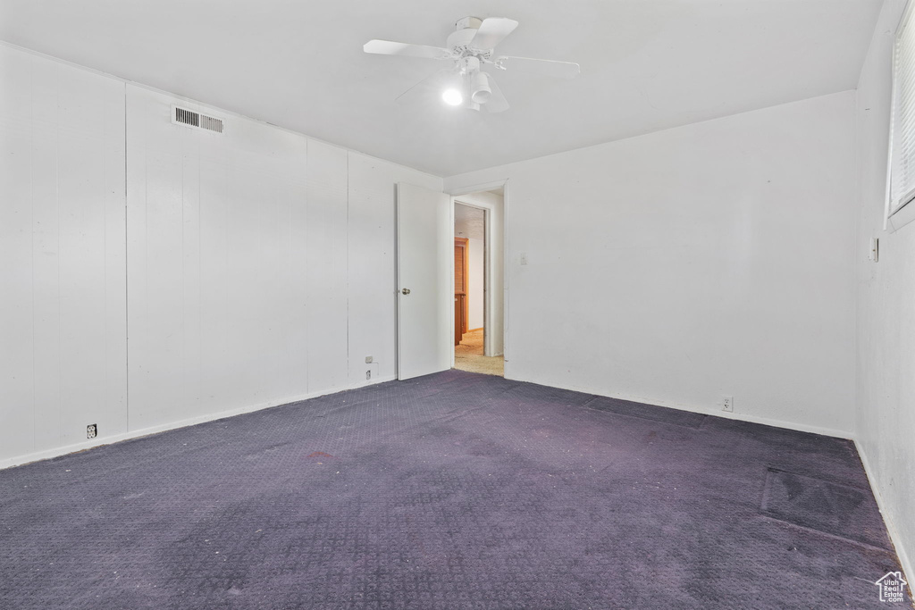 Carpeted empty room featuring ceiling fan