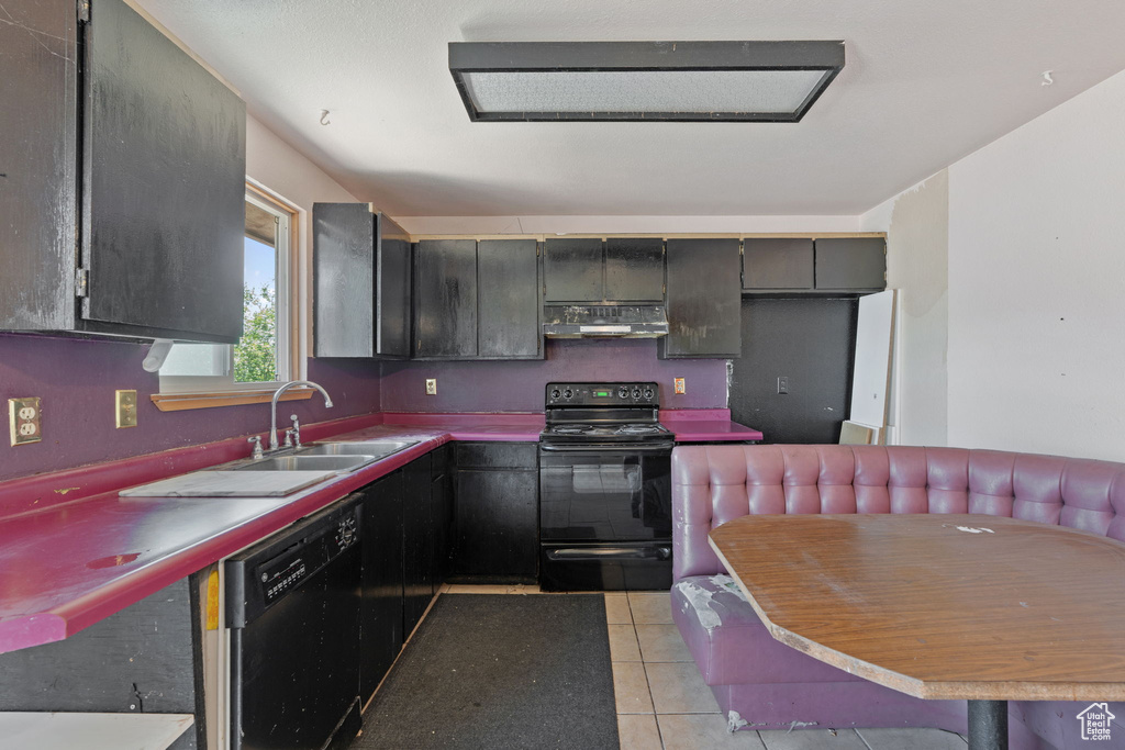 Kitchen featuring black appliances, under cabinet range hood, a sink, and light tile patterned floors