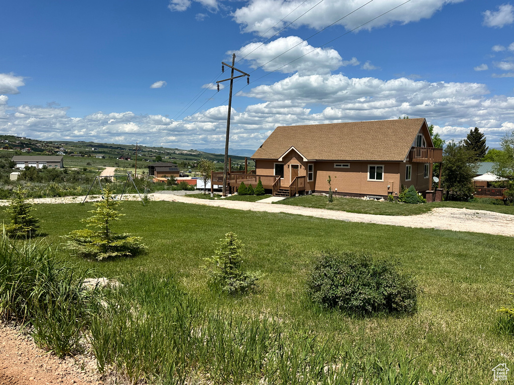 View of front of house with a shingled roof and a front lawn