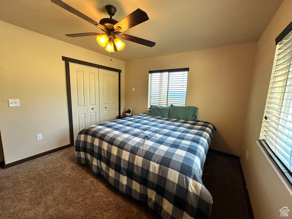 Bedroom with carpet floors, baseboards, a closet, and a ceiling fan