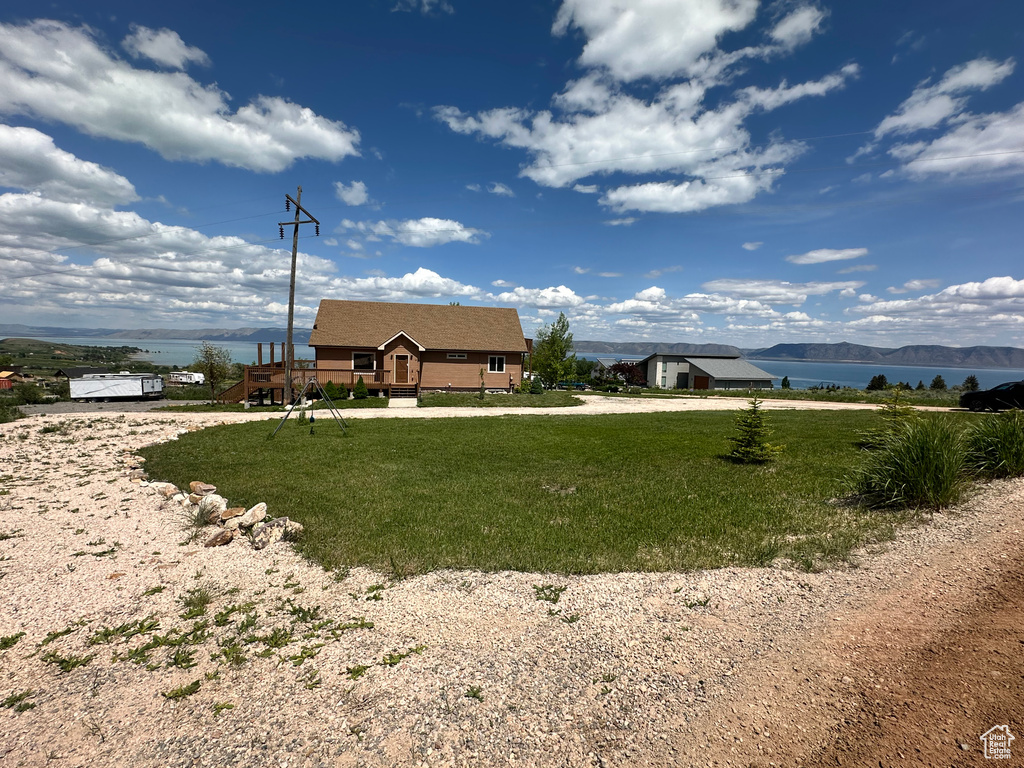 View of grassy yard with a water and mountain view