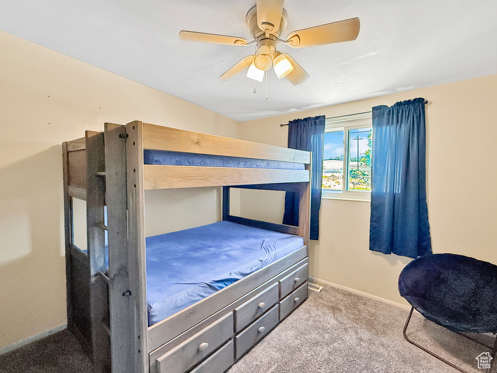 Carpeted bedroom with baseboards and a ceiling fan
